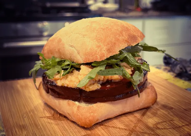 Frazie'S Meat &Amp; Market | Frazie'S Meat &Amp; Market Hand-crafted sandwich featuring layers of eggplant, arugula, and creamy filling on a rustic ciabatta roll, highlighting Frazie's Meat & Market's gourmet offerings.